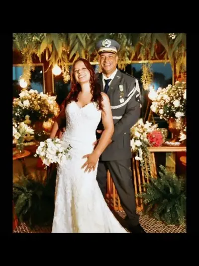 Noivos abraçados em cenário de flores no casamento