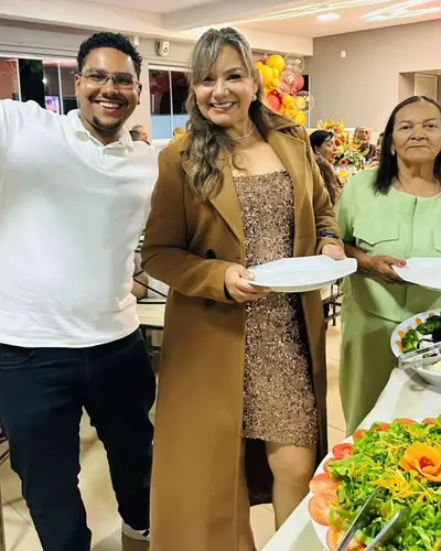Aniversariante e convidados servindo o buffet em festa de 50 anos